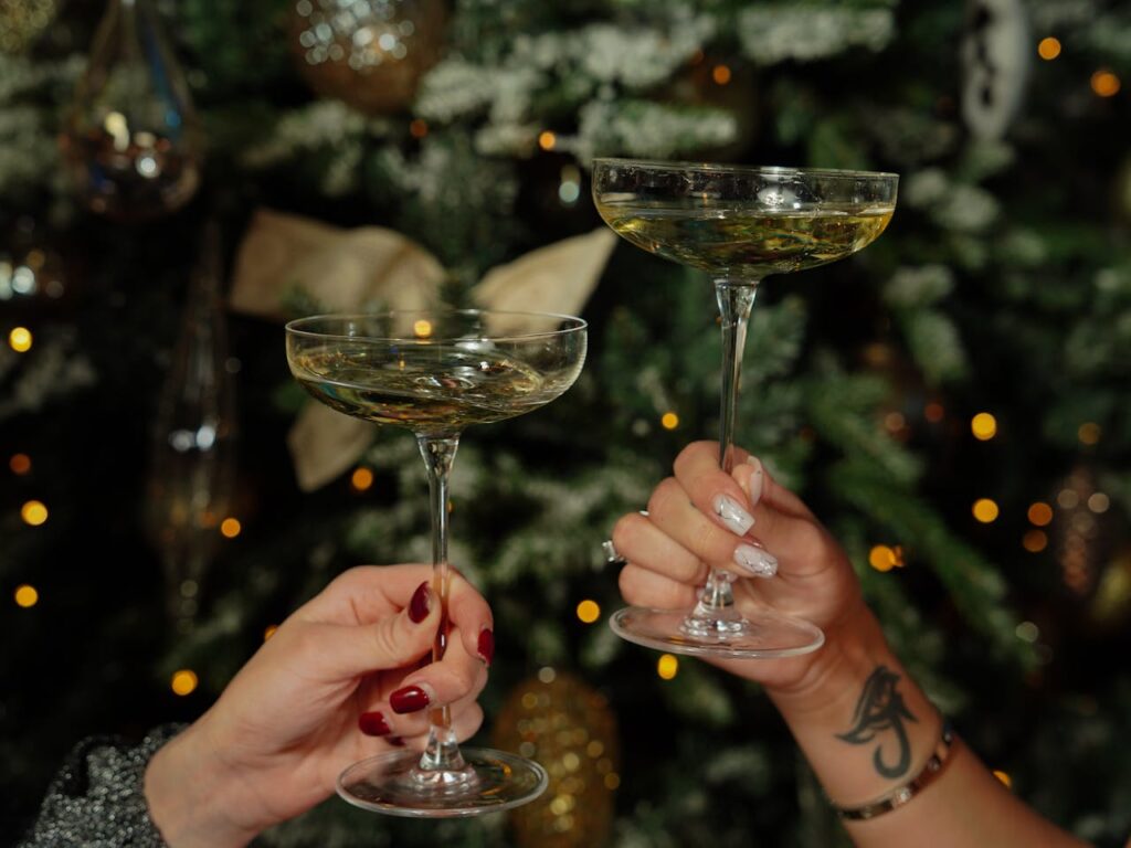 Women Holding Cocktails on the Background of a Christmas Tree