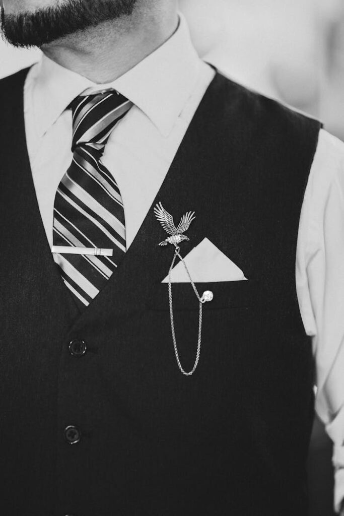 Unrecognizable bearded man in white shirt tie and elegant waistcoat with brooch and chain